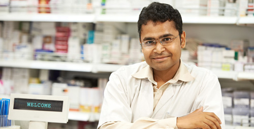 Pharmacist stood in front of medication shelves